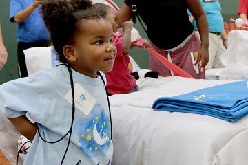 Nadeon Fitzgerald puts on her new backpack during the second annual “Day to Dream” event at the P&G MLB Cincinnati Reds Youth Academy in Roselawn Saturday, Aug. 25, 2018. St. Vincent de Paul - Cincinnati and Morris Furniture Company teamed up to provide 50 children in need with a bed of their own. (CT Photo/E.L. Hubbard)