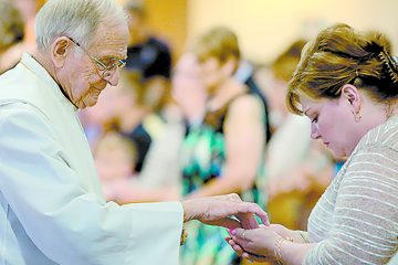 Father William Dorrmann delivers the Holy Eucharist to a parishioner during the St. Aloysius Parish 150th Anniversary Mass in Shandon Saturday, June 2, 2018. (CT Photo/E.L. Hubbard)