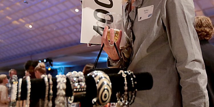 Kathy Wertz looks over the merchandise for sale during RetroFittings 2018, a St. Vincent de Paul fundraising event, at Music Hall in Cincinnati Thursday, Oct. 18, 2018. (CT Photo/E.L. Hubbard)