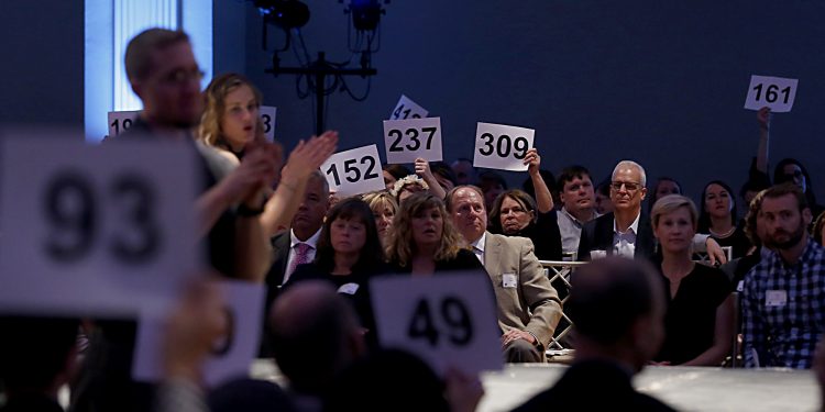 Patrons hold up their numbers to donate during RetroFittings 2018, a St. Vincent de Paul fundraising event, at Music Hall in Cincinnati Thursday, Oct. 18, 2018. (CT Photo/E.L. Hubbard)