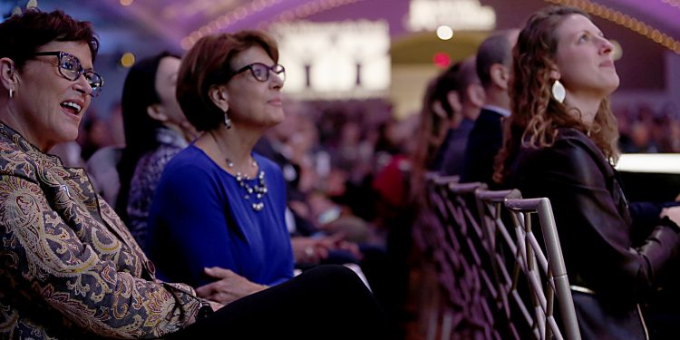 Shelly Maxwell, Jackie Hirt, and Holly Mazzocca watch the fashion show during RetroFittings 2018, a St. Vincent de Paul fundraising event, at Music Hall in Cincinnati Thursday, Oct. 18, 2018. (CT Photo/E.L. Hubbard)