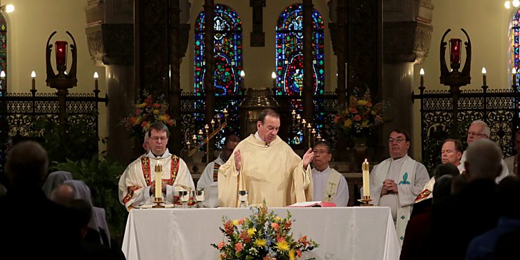 Archbishop Dennis Schnurr prepares the Holy Eucharist for the Mass of Thanksgiving for the 150th Anniversary of the Arrival of the Little Sisters of the Poor in Cincinnati at St. Monica-St. George Parish in Cincinnati Saturday, Oct. 20, 2018. (CT Photo/E.L. Hubbard)