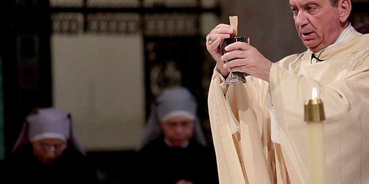 Archbishop Dennis Schnurr prepares the Holy Eucharist for the Mass of Thanksgiving for the 150th Anniversary of the Arrival of the Little Sisters of the Poor in Cincinnati at St. Monica-St. George Parish in Cincinnati Saturday, Oct. 20, 2018. (CT Photo/E.L. Hubbard)