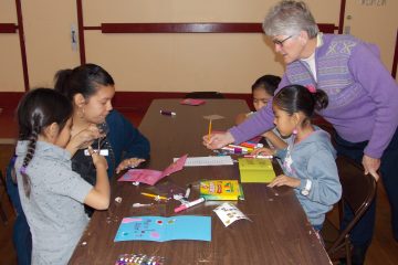 Sister Zoe Brenner helps children make cards for tribal elders. (Courtesy Photo)