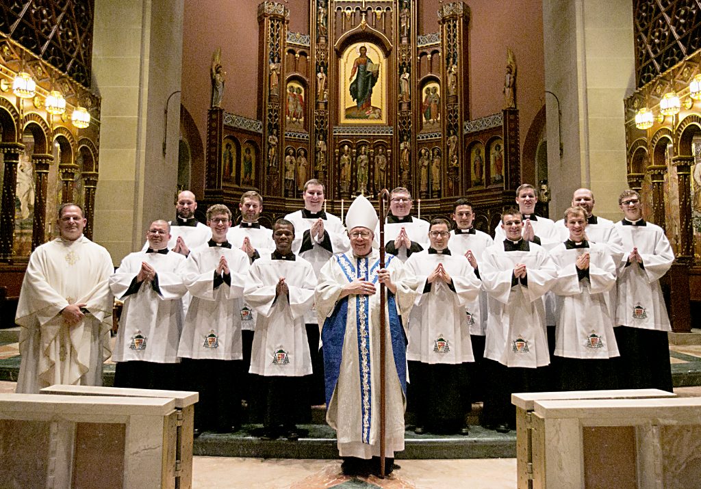 Photo Credit (l to r) Front Row: Father Anthony Brausch, Randolfo Lemus Arias, Alexander Elfreich, Chibueze Asiegbulem, Bishop Joseph Binzer, Kevin LeMelle, Michael Willig, Jacob Lindle. Second Row: Robert Hale, Thomas Hunyor, Jr., Benjamin Dollarhide, Stephen Jones, Elvis Hernan Aguilar, Ethan Hoying, Broderick Witt, J. Tyler Marsh. (Photo by E L Hubbard)