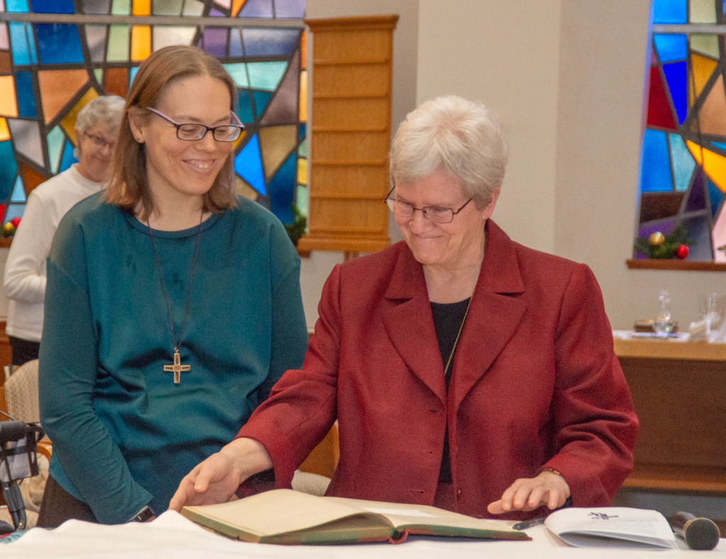 Sister Carol Lichtenberg, Provincial, and Sister Sarah Cieplinski sign the official register of Perpetual Vows, indicating Sarah’s gift of her complete life to God.  (Courtesy Photo)