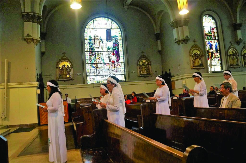 Women from Our Lady of Lavang Vietnamese Catholic Community take part in the Good Friday 15-station lamentation to mourn the suffering and death of our Lord. The white headband and outfit are customary to wear at the funerals of loved ones.  (Courtesy Photo)