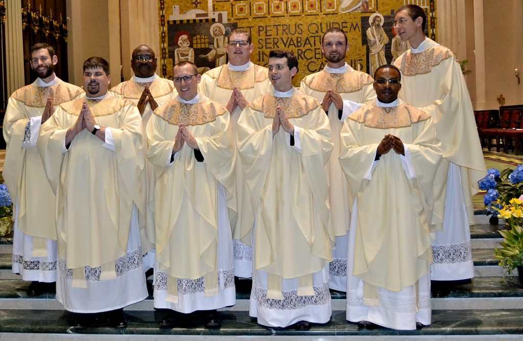 Front Row L to R: Father Mark Bredstege, Father Jeff Stegbauer, Father Andrew Hess, Father Alex Alex Biryomumeisho; Back Row from L to R; Father Ambrose Dobrozsi, Father Elias Mwesigye, Father Zach Cecil, Father Jedidiah Tritle, and Father Christian Cone-Lombarte (CT Photo/Greg Hartman)