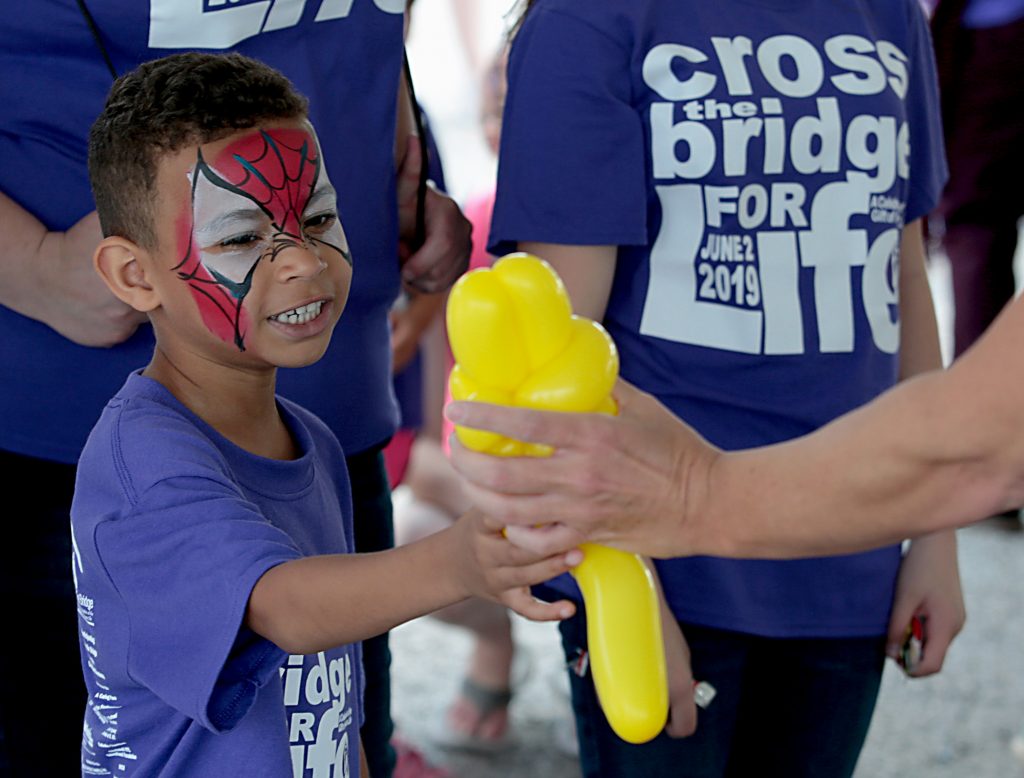 Jaden Stephens, 5, smiles as he receives a balloon animal during the Cross the Bridge for Life in Newport, Ky. Sunday, June 2, 2019. (CT Photo/E.L. Hubbard)