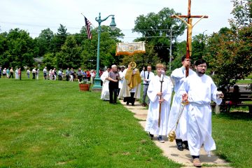 Our Lady of the Rosary parishioner Joshua Vietas leads the congregation around the Greenhills Commons during the parish's Fourth Annual Feast of Corpus Christi Procession on Sunday, June 23. Members of the church process to the Commons's gazebo where the Blessed Sacrament is displayed during a brief service. Following a homily by Our Lady of the Rosary pastor, Fr. Alex McCullough, the Blessed Sacrament is returned to the church for a final blessing and placed in the tabernacle. (CT Photo/ David A. Moodie,)