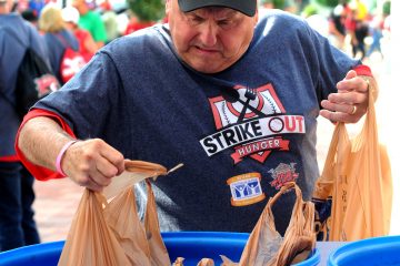 St. Vincent de Paul volunteer Steve Taylor places bags of donated food into a collection bin outside of Great American Ballpark on Friday, May 31. SVdP collected food from patrons of the Reds games on Friday and Saturday, May 31 and June 1, during their “Strike Out Hunger" campaign. Game patrons who donated three or more non-perishable foods were awarded tickets to a future Reds game. Last year’s drive collected over three tons of food, which fed approximately 5,300 families. (CT photo/David A. Moodie)