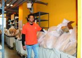 St. Joseph Orphanage’s Behavior Support Specialist, Willie Wright, packs bags of food alongside other education team members to be delivered to the homes of students.