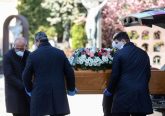 Undertakers wearing face masks carry a coffin in a cemetery in Bergamo, Italy, March 16, 2020. Credit: AFP via Getty Images