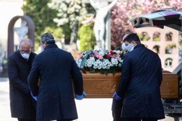 Undertakers wearing face masks carry a coffin in a cemetery in Bergamo, Italy, March 16, 2020. Credit: AFP via Getty Images