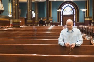 David Cooley, editorial director of The Catholic Telegraph, prays the Rosary at St. Xavier Church