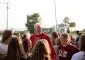 Priest wearing red stands among group of young women